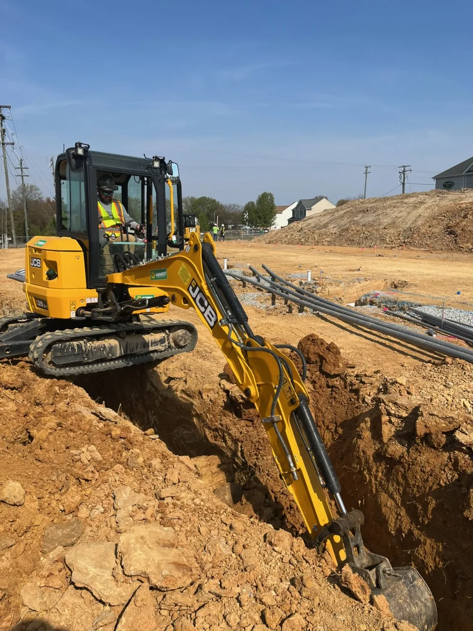 Mini excavator trenching a run for underground electrical conduit